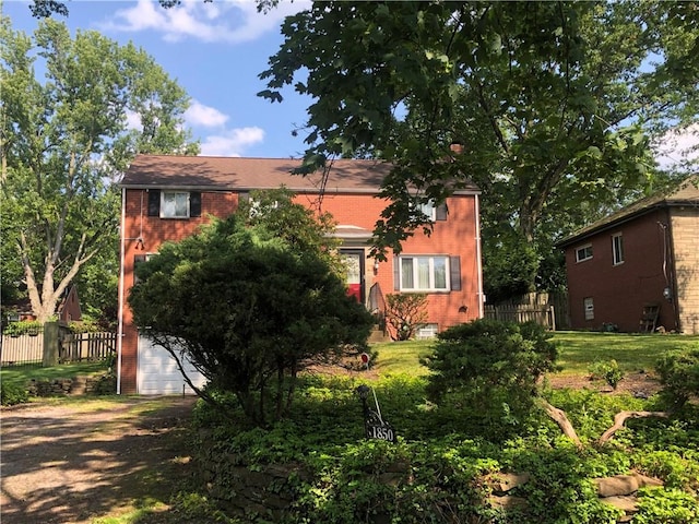 1850 Graham Blvd, Wilkinsburg, PA 15235 - obstructed view of property featuring brick siding, an attached garage, and dirt driveway