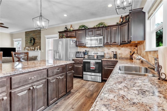 201 Millstream Ln, Zelienople Boro, PA 16063 - kitchen featuring appliances with stainless steel finishes, a chandelier, healthy amount of natural light, dark brown cabinets, and ornamental molding