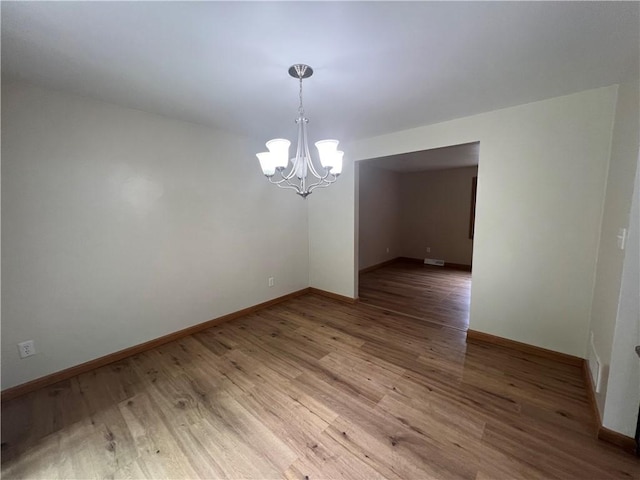 742 King St, Mckeesport, PA 15132 - empty room with a chandelier and light wood finished floors