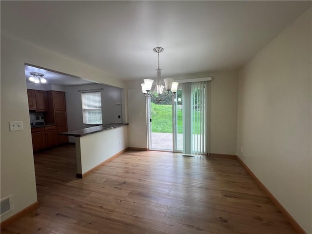 742 King St, Mckeesport, PA 15132 - unfurnished dining area with light wood-style flooring and a chandelier
