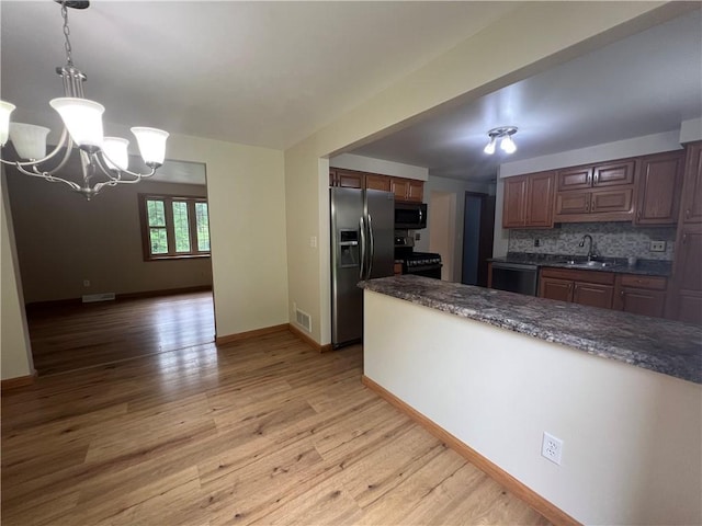 742 King St, Mckeesport, PA 15132 - kitchen with stainless steel refrigerator with ice dispenser, gas stove, light wood finished floors, dishwasher, and a chandelier