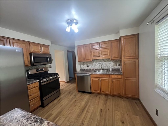 742 King St, Mckeesport, PA 15132 - kitchen with stainless steel appliances, light wood-style flooring, backsplash, and brown cabinets