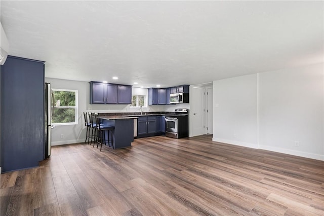 105 Becks Run Rd, Moon/Crescent Twp, PA 15108 - kitchen featuring appliances with stainless steel finishes, a kitchen breakfast bar, dark countertops, dark wood finished floors, and recessed lighting
