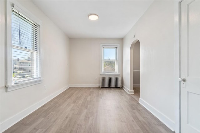 3937 Davis Ave, Munhall, PA 15120 - unfurnished room with radiator, arched walkways, plenty of natural light, and light wood-style flooring