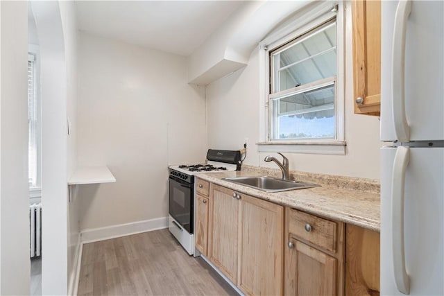3937 Davis Ave, Munhall, PA 15120 - kitchen featuring freestanding refrigerator, range with gas stovetop, light brown cabinetry, light wood-type flooring, and light countertops