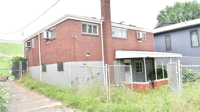 3550 Camp St, Hill District, PA 15219 - rear view of property featuring brick siding, a gate, and a chimney
