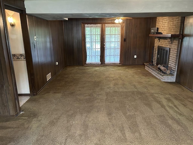 307 Debora Dr, Latrobe, PA 15650 - unfurnished living room with carpet, wooden walls, a fireplace, and ceiling fan