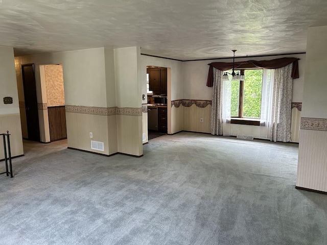 307 Debora Dr, Latrobe, PA 15650 - unfurnished living room with wainscoting, carpet floors, and a textured ceiling
