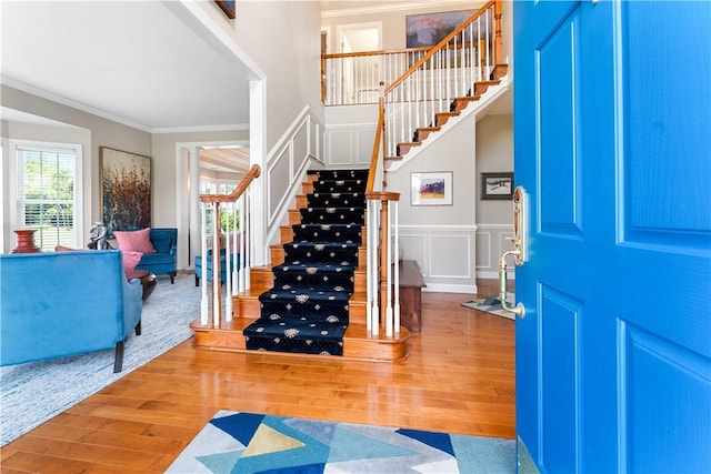 1002 Sunset Way, Menallen Twp, PA 15401 - entrance foyer featuring crown molding, wood finished floors, stairway, a decorative wall, and a wainscoted wall