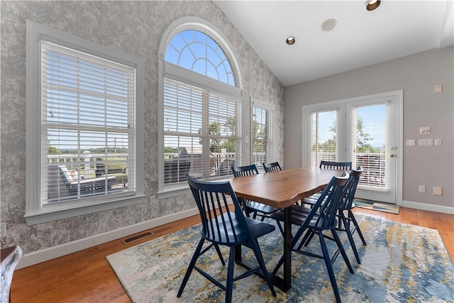 1002 Sunset Way, Menallen Twp, PA 15401 - dining space with plenty of natural light, vaulted ceiling, wallpapered walls, and light wood-type flooring