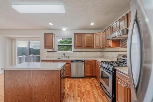 520 Panorama Dr, Cecil, PA 15317 - kitchen with appliances with stainless steel finishes, under cabinet range hood, light wood-style floors, light countertops, and a kitchen island