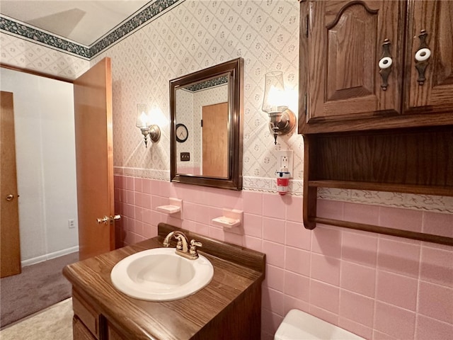 240 Reed St, Lower Burrell, PA 15068 - bathroom with vanity, wallpapered walls, tile walls, and a wainscoted wall
