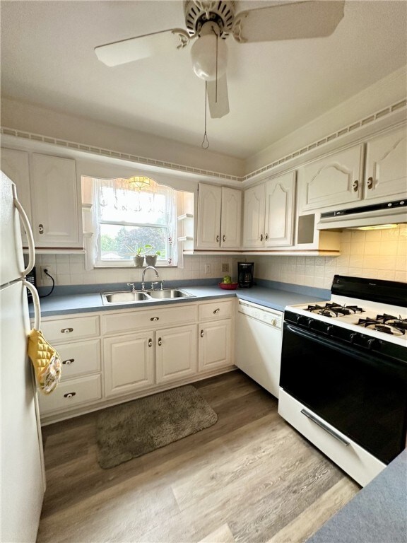 240 Reed St, Lower Burrell, PA 15068 - kitchen with white appliances, under cabinet range hood, light wood-style floors, decorative backsplash, and a ceiling fan
