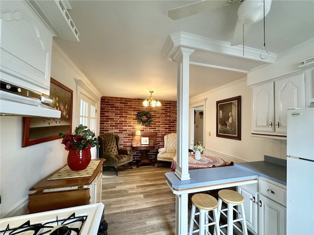 240 Reed St, Lower Burrell, PA 15068 - kitchen featuring freestanding refrigerator, white cabinets, ornamental molding, light wood-style flooring, and a kitchen breakfast bar