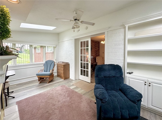 240 Reed St, Lower Burrell, PA 15068 - living area with a skylight, ceiling fan, light wood finished floors, brick wall, and lofted ceiling