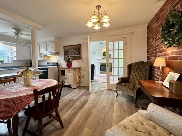 240 Reed St, Lower Burrell, PA 15068 - dining room with a ceiling fan, light wood-type flooring, a chandelier, crown molding, and a brick fireplace