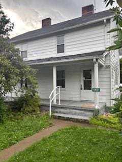 325 Back St, Mount Pleasant Twp Wml, PA 15666 - rear view of house with a porch and a chimney