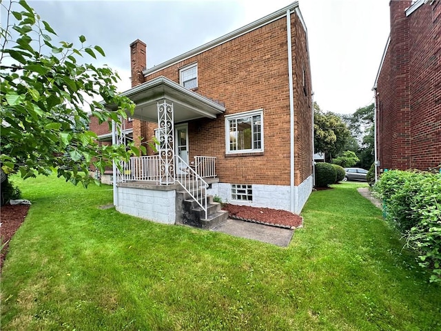 7207 Mcclure Ave, Swissvale, PA 15218 - back of house with brick siding, a chimney, and a lawn