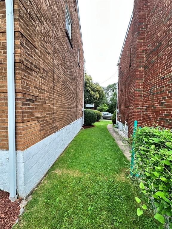 7207 Mcclure Ave, Swissvale, PA 15218 - view of home's exterior with brick siding and a lawn