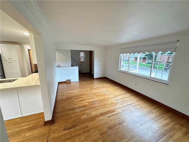 7207 Mcclure Ave, Swissvale, PA 15218 - spare room featuring crown molding, stairway, and light wood-style floors