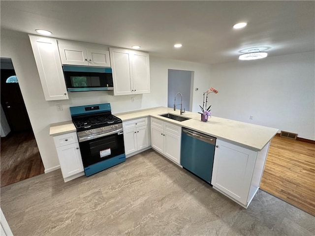 7207 Mcclure Ave, Swissvale, PA 15218 - kitchen featuring stainless steel appliances, a peninsula, light countertops, white cabinetry, and recessed lighting