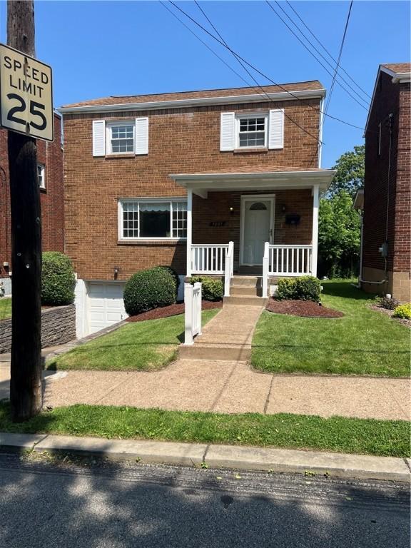 7207 Mcclure Ave, Swissvale, PA 15218 - view of front facade featuring brick siding, covered porch, and a garage