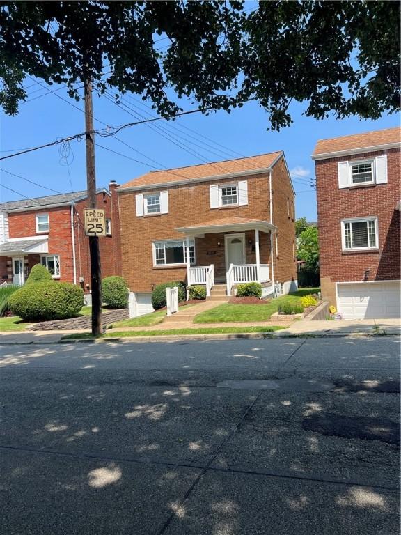 7207 Mcclure Ave, Swissvale, PA 15218 - view of front facade with a porch, a garage, and brick siding