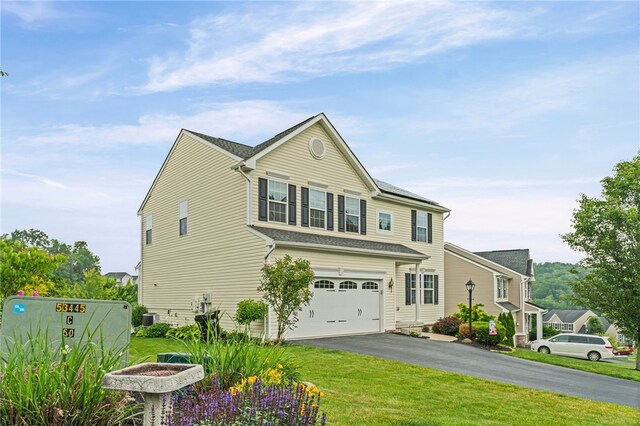 161 Buckingham Dr, Ohio Twp, PA 15237 - view of front of home featuring an attached garage, asphalt driveway, a front lawn, and roof mounted solar panels