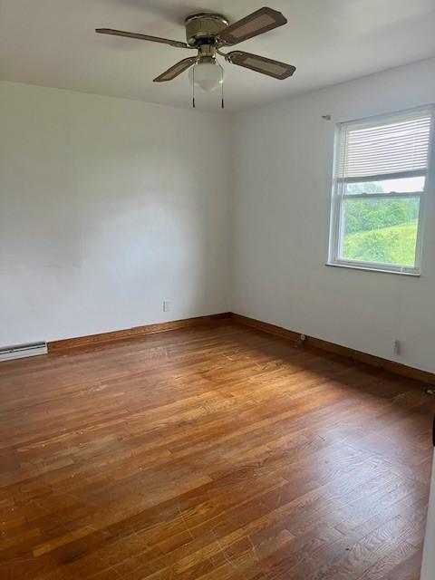82 Crossridge, Crossridge, PA 15022 - spare room featuring wood finished floors, ceiling fan, and baseboard heating