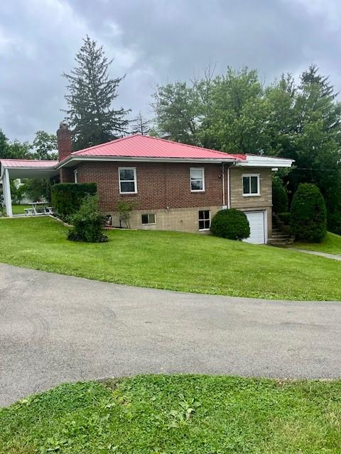 82 Crossridge, Crossridge, PA 15022 - view of side of home featuring a chimney, a garage, a lawn, a metal roof, and driveway