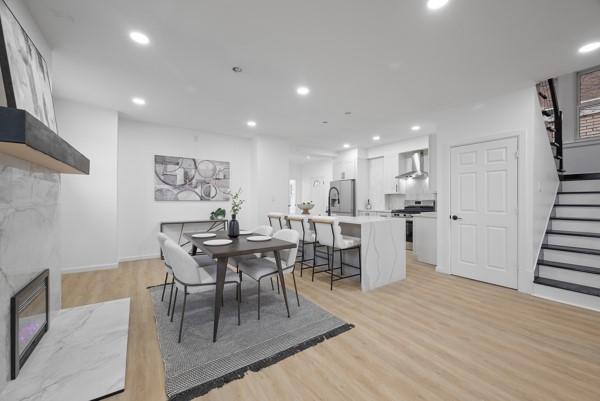 2356 Pittock St, Squirrel Hill, PA 15217 - dining space with light wood-style floors, stairway, a high end fireplace, and recessed lighting