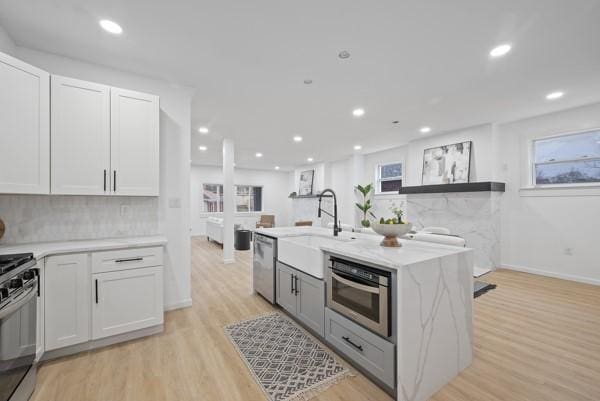 2356 Pittock St, Squirrel Hill, PA 15217 - kitchen with appliances with stainless steel finishes, light wood-style floors, backsplash, recessed lighting, and light stone counters