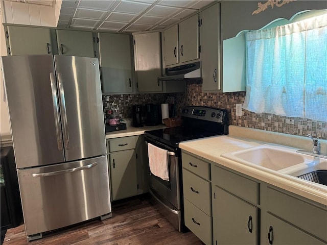 515 Pike Run Dr W, Pike Run Twp, PA 15427 - kitchen featuring appliances with stainless steel finishes, under cabinet range hood, tasteful backsplash, light countertops, and dark wood-type flooring