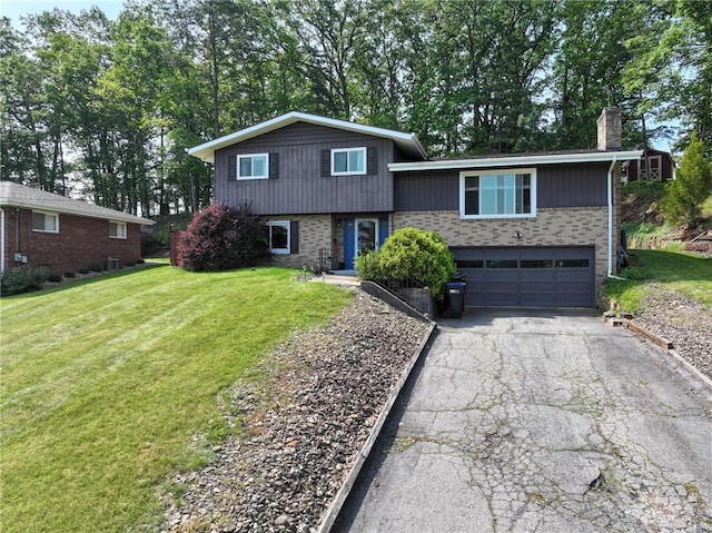 215 Columbia Dr, Center Twp Bea, PA 15001 - split level home with a garage, driveway, brick siding, a chimney, and a front yard
