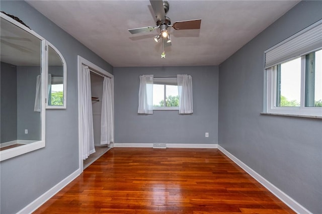 215 Columbia Dr, Center Twp Bea, PA 15001 - unfurnished bedroom with multiple windows, wood finished floors, and a ceiling fan