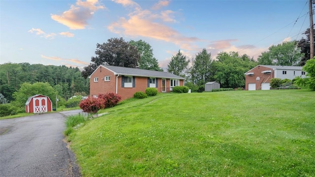 108 Tanglewood Dr, Middlesex Twp, PA 16059 - ranch-style home featuring a storage shed, a lawn, brick siding, and a garage