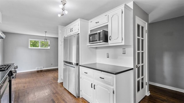 108 Tanglewood Dr, Middlesex Twp, PA 16059 - kitchen with appliances with stainless steel finishes, dark countertops, white cabinetry, dark wood-style flooring, and decorative light fixtures