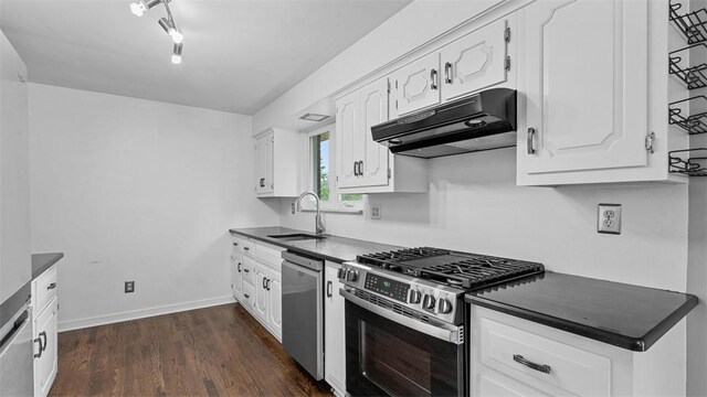 108 Tanglewood Dr, Middlesex Twp, PA 16059 - kitchen with appliances with stainless steel finishes, under cabinet range hood, dark countertops, and white cabinetry