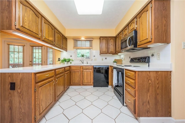 221 William Dr, North Strabane, PA 15317 - kitchen featuring black dishwasher, electric stove, stainless steel microwave, brown cabinetry, and a peninsula