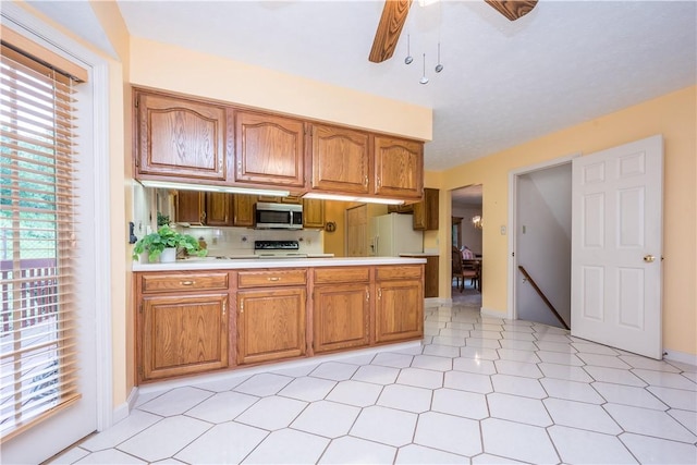 221 William Dr, North Strabane, PA 15317 - kitchen featuring stainless steel microwave, white refrigerator with ice dispenser, light countertops, and brown cabinetry