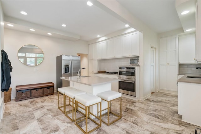 1463 Beechwood Blvd, Squirrel Hill, PA 15217 - kitchen featuring appliances with stainless steel finishes, decorative backsplash, recessed lighting, white cabinets, and a kitchen bar