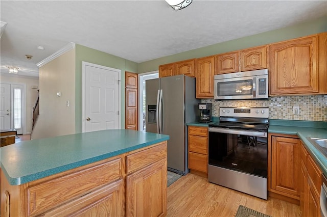 6032 Hawthorn Dr, Moon/Crescent Twp, PA 15108 - kitchen with appliances with stainless steel finishes, light wood-style flooring, decorative backsplash, a kitchen island, and crown molding