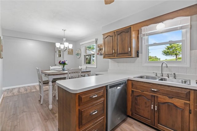 160 Sonnie Dr, Salem Twp Wml, PA 15624 - kitchen with dishwasher, light countertops, a chandelier, light wood-style floors, and decorative backsplash