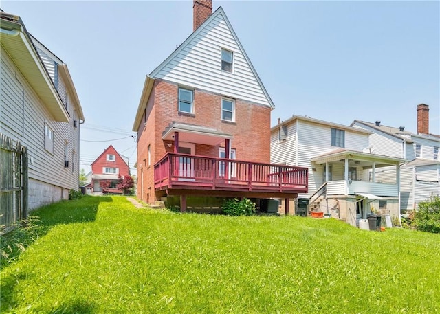 1709 Main St, Aliquippa, PA 15001 - rear view of house with brick siding, a chimney, a wooden deck, and a lawn