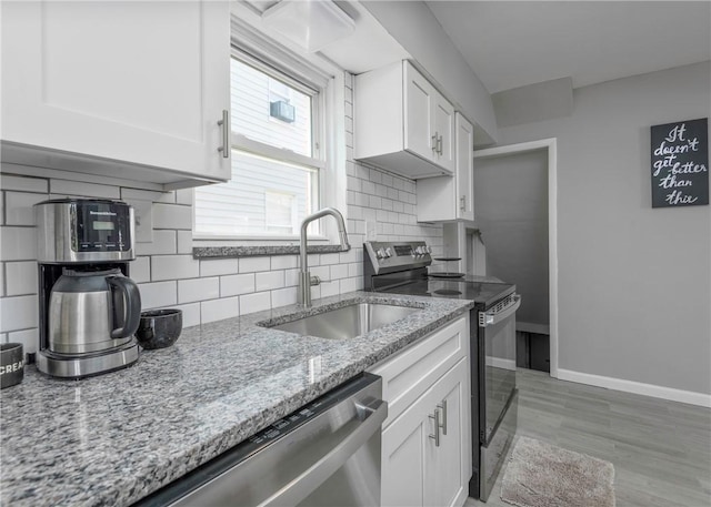 1709 Main St, Aliquippa, PA 15001 - kitchen featuring appliances with stainless steel finishes, white cabinetry, backsplash, and light stone counters