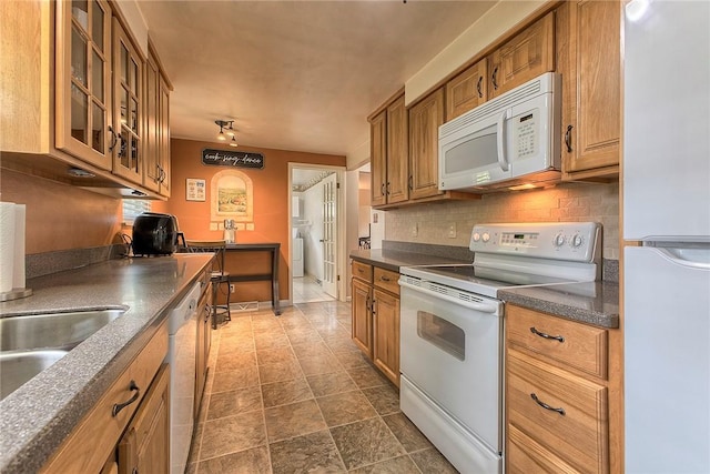 712 N 2nd St, Jeannette, PA 15644 - kitchen with white appliances, dark countertops, brown cabinets, and decorative backsplash