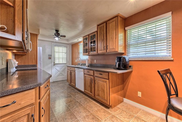 712 N 2nd St, Jeannette, PA 15644 - kitchen with dishwasher, brown cabinetry, ceiling fan, glass insert cabinets, and range