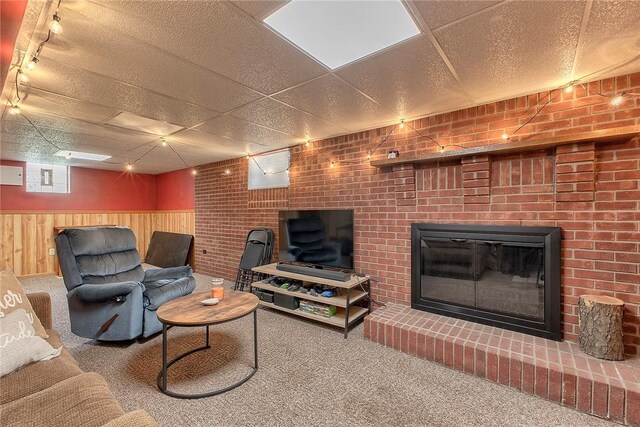 712 N 2nd St, Jeannette, PA 15644 - living area with carpet floors, a paneled ceiling, a fireplace, wainscoting, and wooden walls