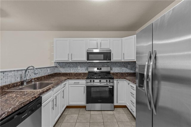 2960 Brevard Ave, Brentwood, PA 15227 - kitchen with stainless steel appliances, white cabinetry, tasteful backsplash, light tile patterned floors, and dark stone countertops