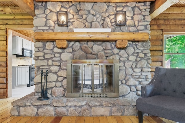 125 Timber Ridge Rd, Clinton Twp, PA 16056 - detailed view of range with gas stovetop, log walls, wood finished floors, and stainless steel microwave